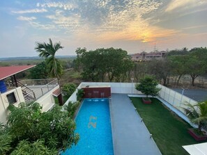 Une piscine offrant une vue sur un quartier résidentiel et sur le coucher du soleil.
