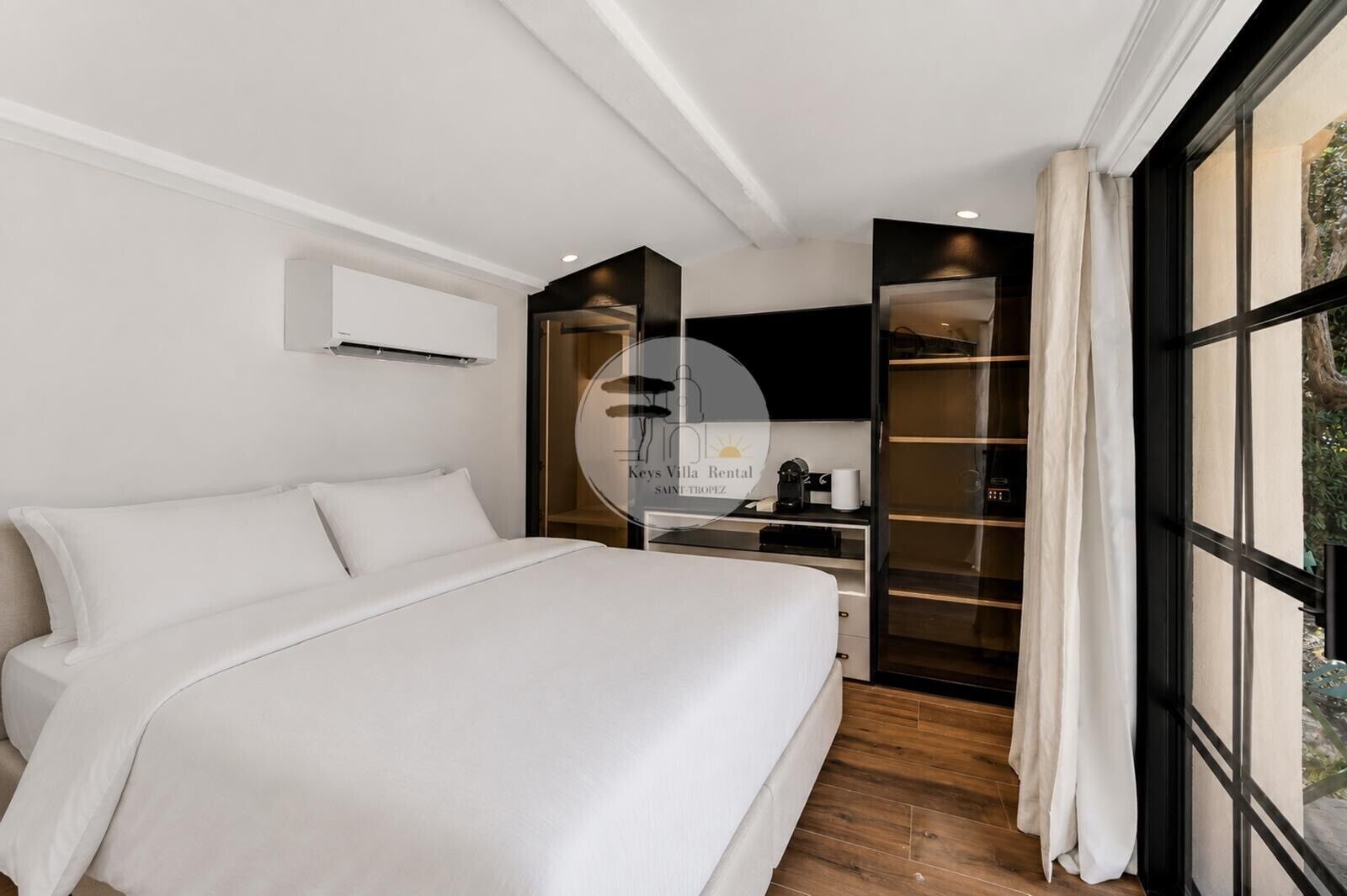 Ein modernes Schlafzimmer mit einem großen Bett, einem eingebauten Kleiderschrank und Blick durch ein Fenster.