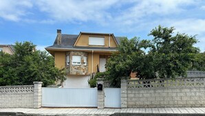 A residential house with a stone facade, a gated entrance, and a clear sky. - Family home with a garden: Beach, mountains, and pets welcome (Garage included) (La Caridad)