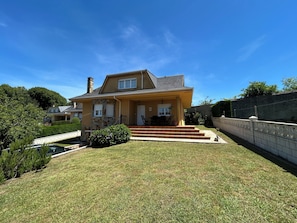 A two-story house with a front porch, a stone facade, and a well-maintained lawn.