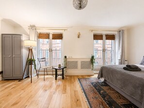 A bedroom with a bed, a desk, a chair, a lamp, and a wardrobe. - Central Garden Townhouse near Oxford St and SoHo (London)