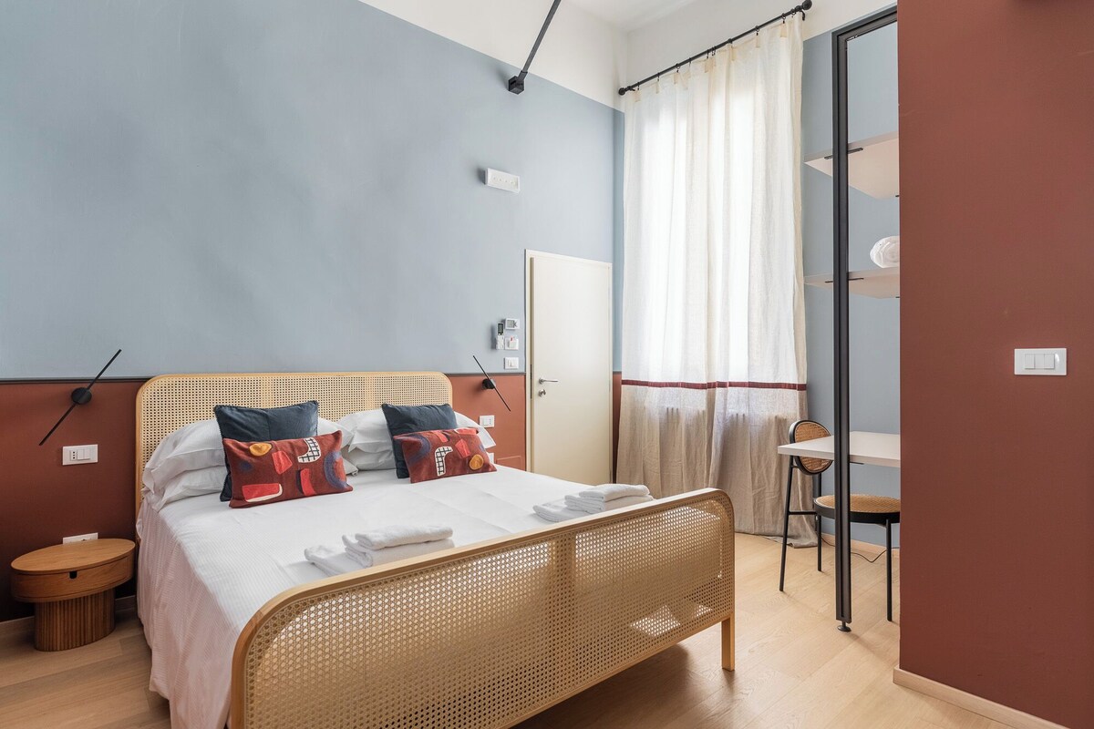 Ein Schlafzimmer mit einem Bett, einem Nachttisch und einem Sessel.