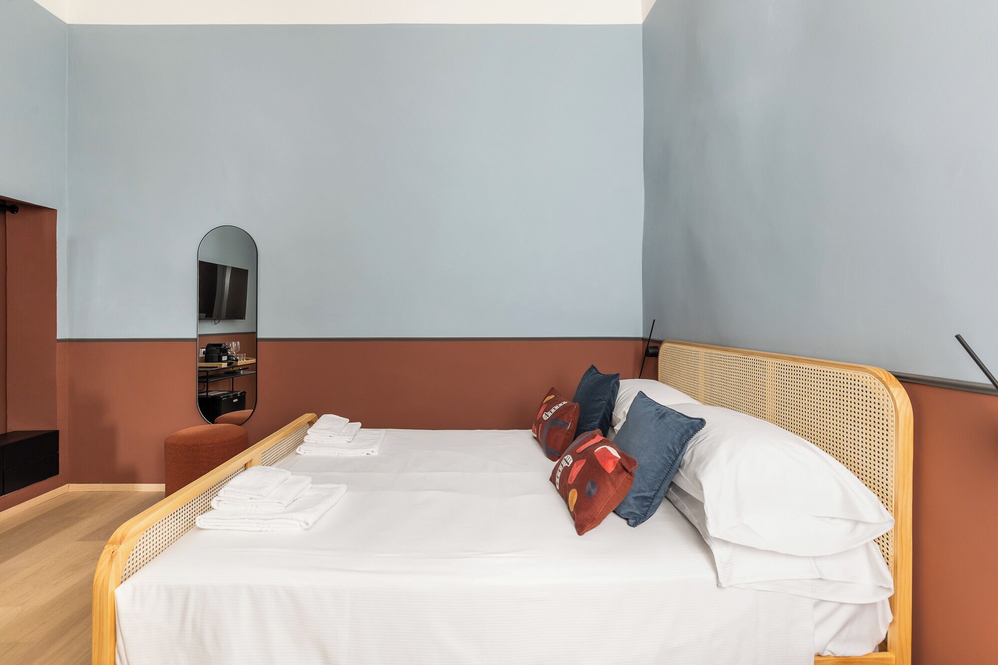 Ein Hotelzimmer mit einem Bett, einem Flachbildfernseher und einem Spiegel.