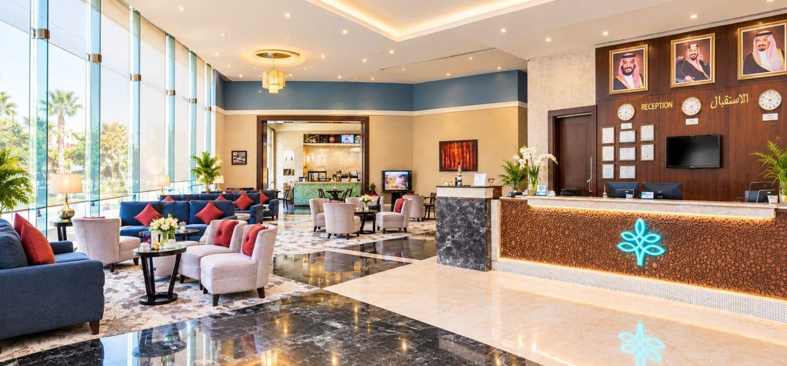 Vestíbulo de hotel con recepción, zona de estar y vistas al exterior.