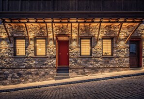 A stone building with a red door, wooden beams, and stone walls.
