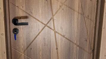 A wooden door with a geometric pattern and a keyhole.