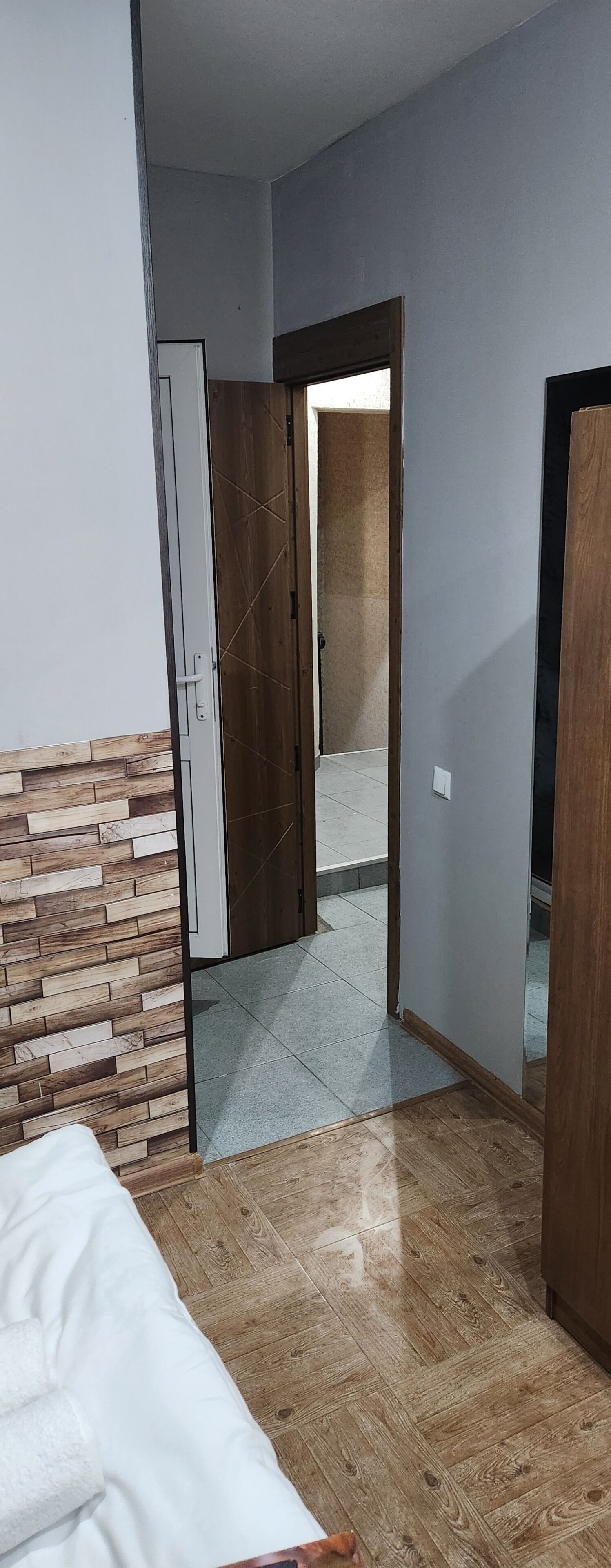Una habitación con una cama, un armario y una puerta que da a otra habitación.