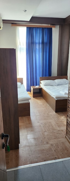 Habitación triple familiar, vistas a la ciudad | Escritorio, espacio para trabajar con un portátil, cortinas opacas