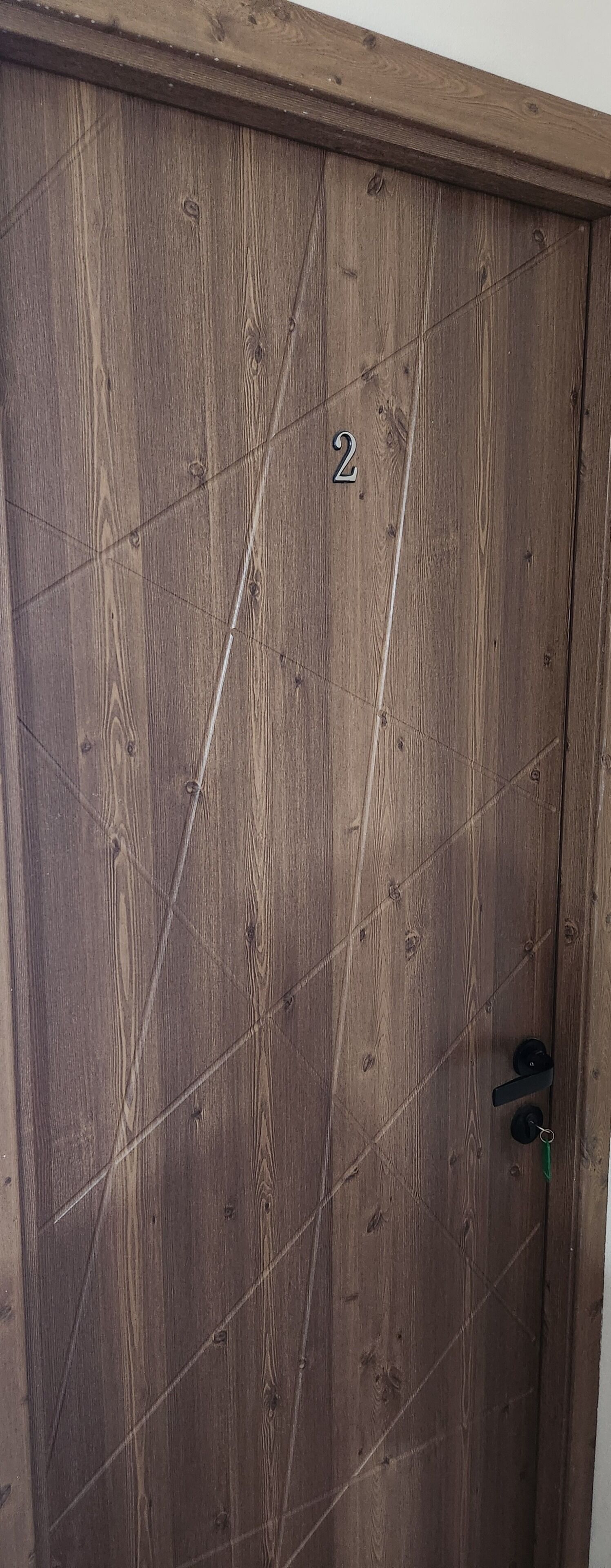 Una puerta de madera con el número 2 y una cerradura.