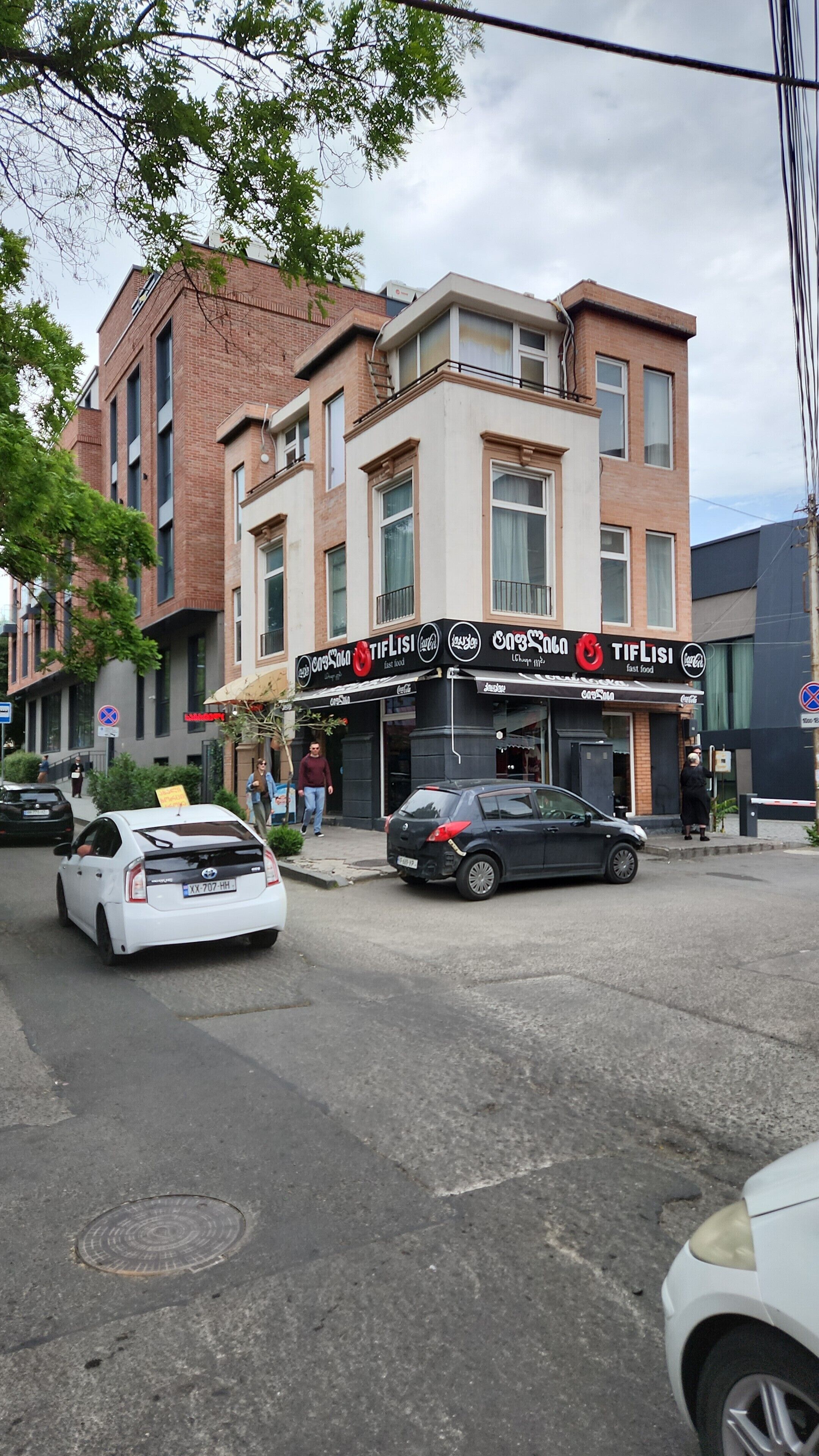 Un edificio con escaparate que muestra un anuncio de Coca-Cola y un cartel con el nombre 'TifLisi'.
