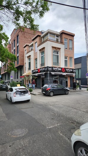 Un edificio con escaparate que muestra un anuncio de Coca-Cola y un cartel con el nombre 'TifLisi'.