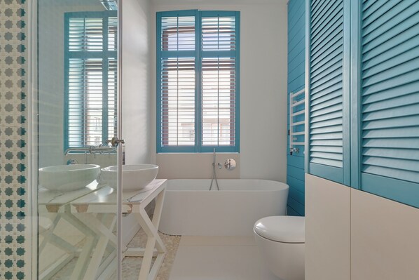 A bathroom with a bathtub, two sinks, and a toilet.