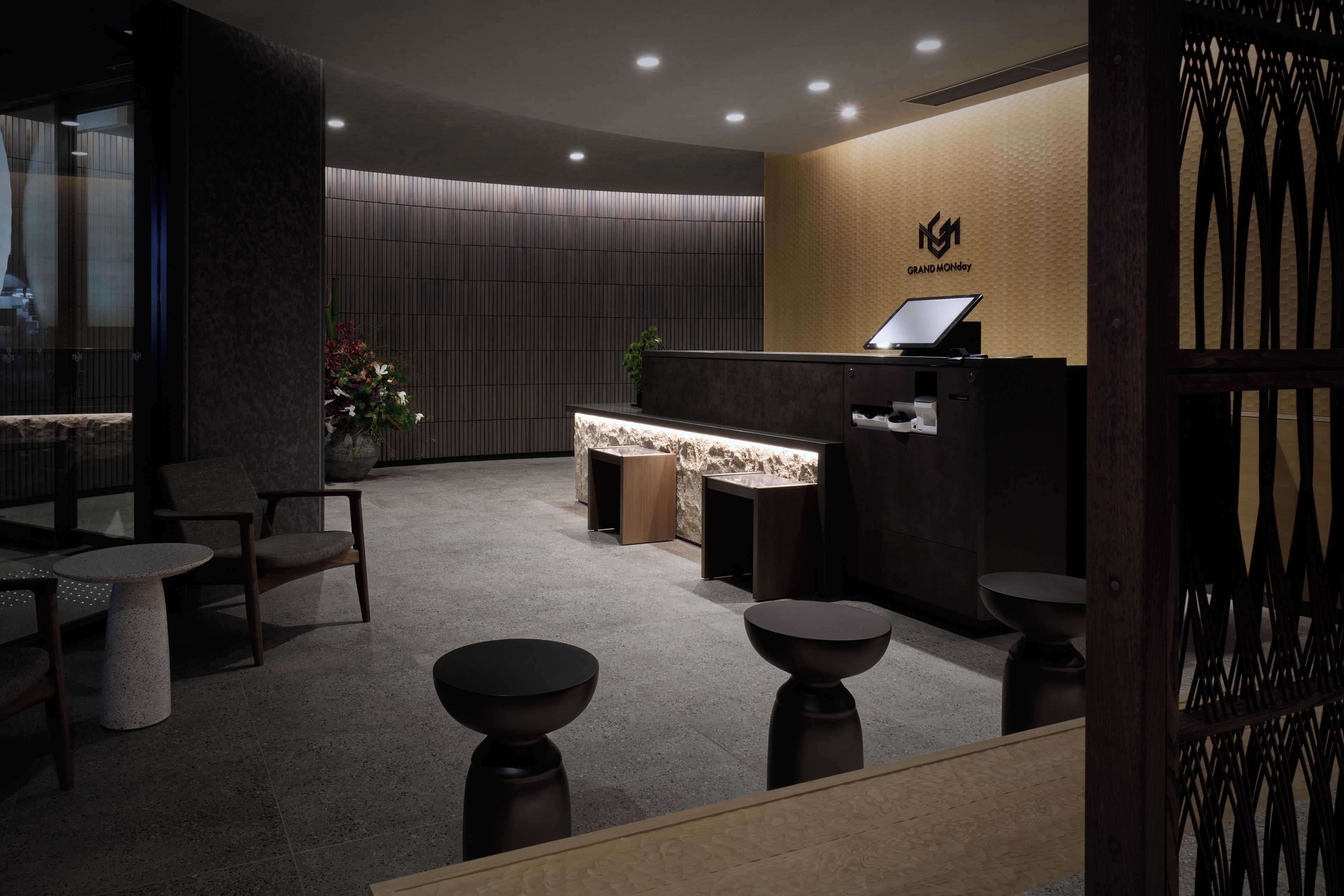 Un área de recepción con mostrador, asientos y una pared con un logotipo.