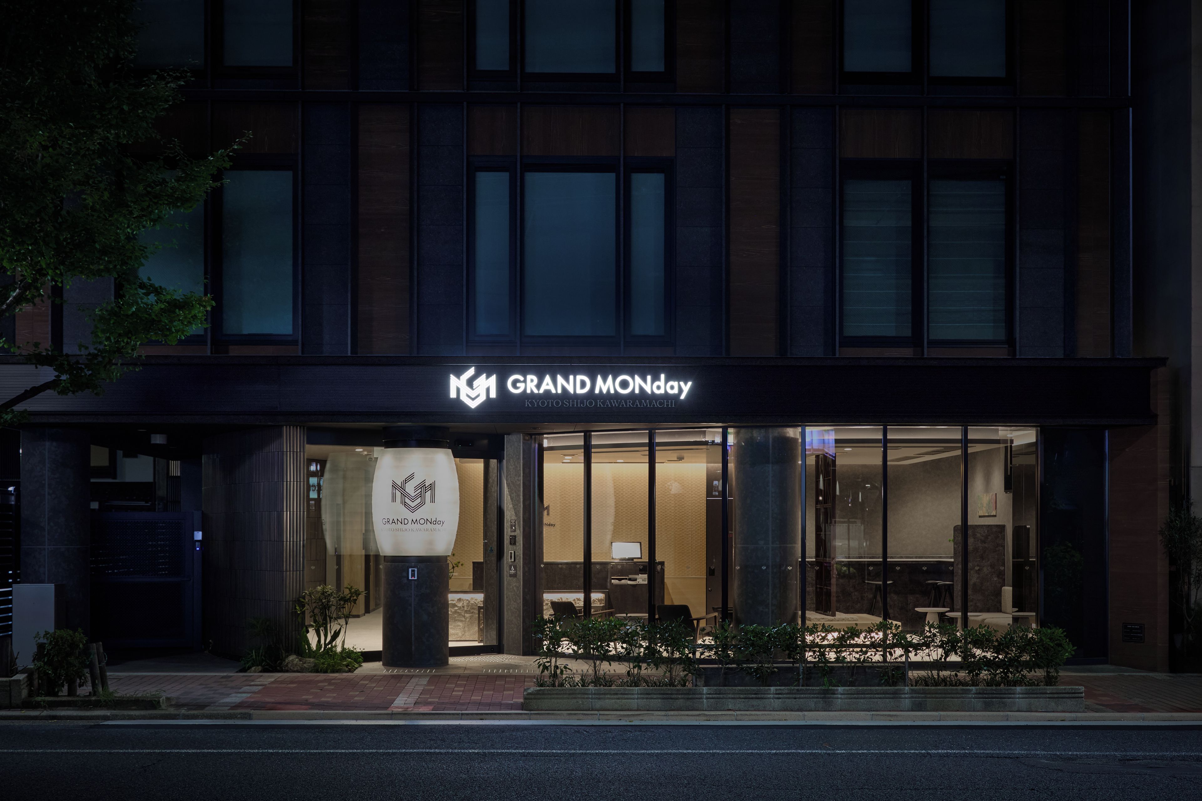 A hotel entrance with a sign reading 'GRAND MONDAY' and a logo.