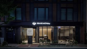 A hotel entrance with a sign reading 'GRAND MONDAY' and a logo.