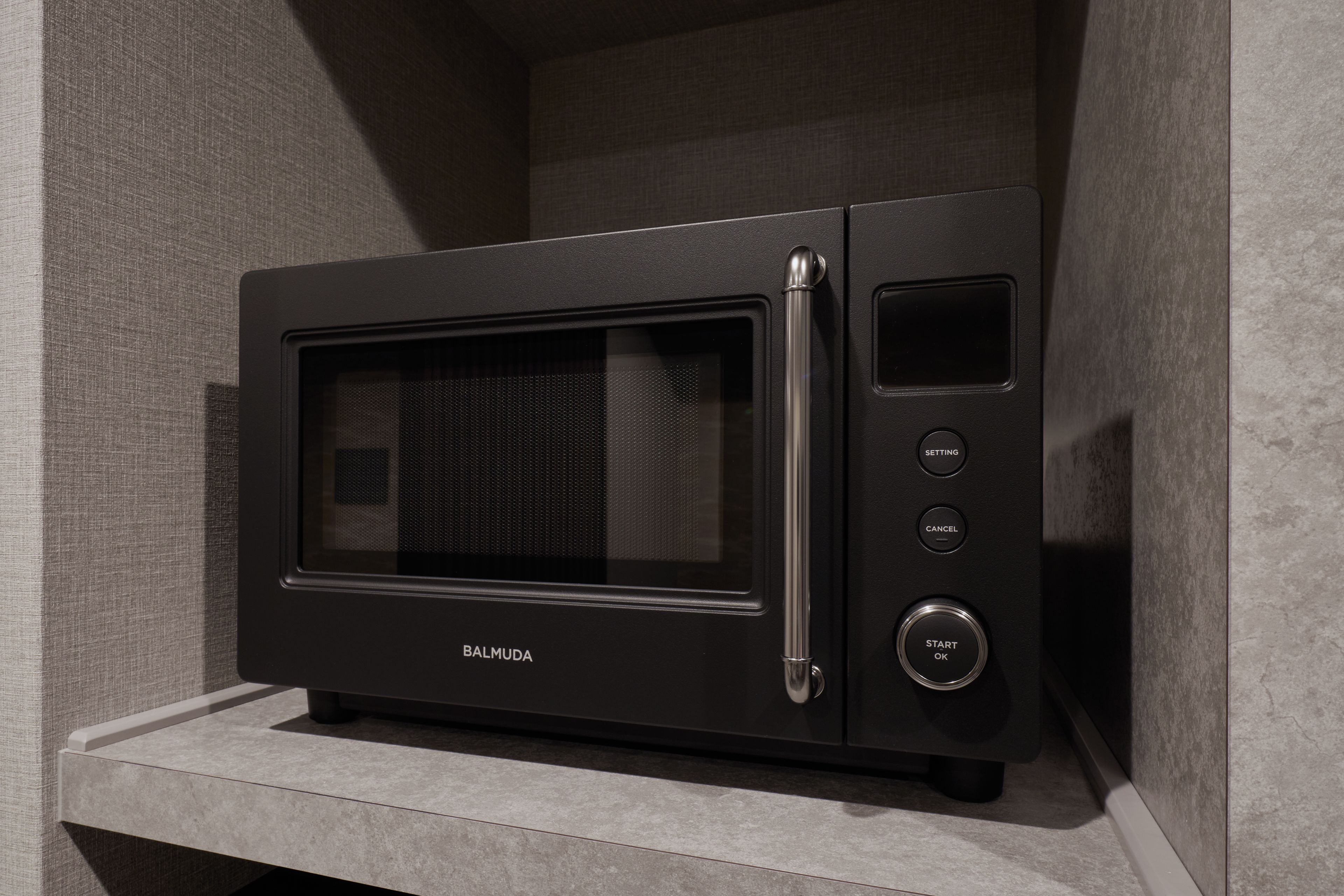 A black microwave oven with a digital display and control buttons on a countertop.