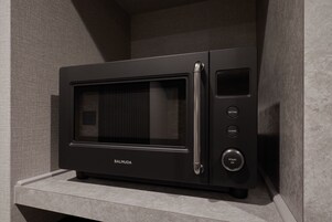 A black microwave oven with a digital display and control buttons on a countertop.