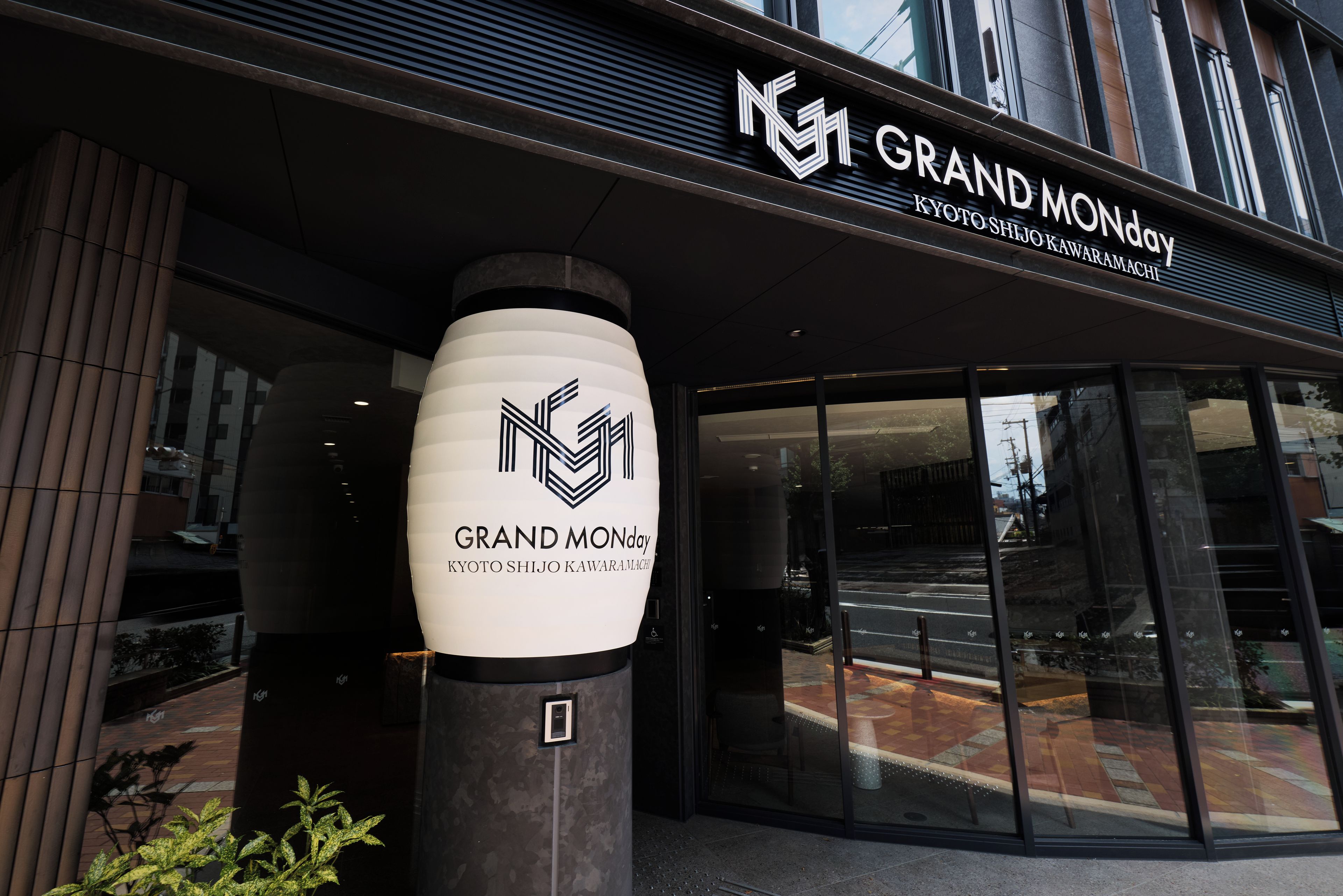 The entrance to a hotel with a prominent sign reading 'GRAND MONDAY' and 'KYOTO SHIJO KAWARAMACHI'.