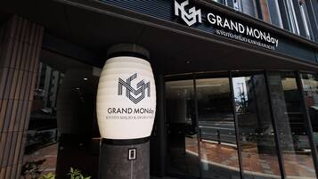 The entrance to a hotel with a prominent sign reading 'GRAND MONDAY' and 'KYOTO SHIJO KAWARAMACHI'.