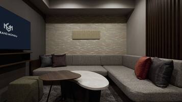 A modern living room with a sectional sofa, a round coffee table, and a small ottoman.