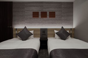 A hotel room with two beds, a wooden headboard, and a modern wall design.