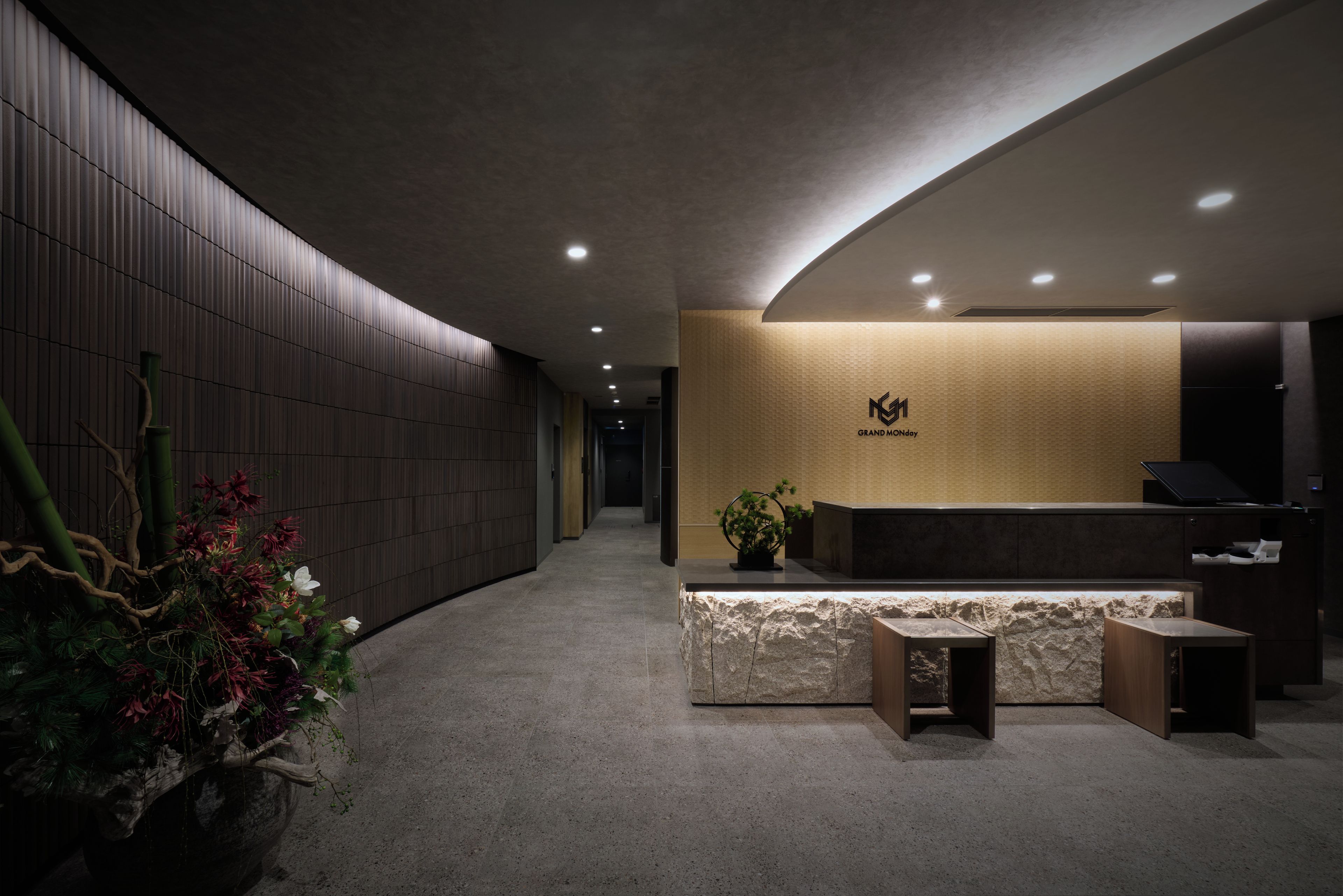 A reception area with a reception desk, a wall-mounted logo, and a reception counter.