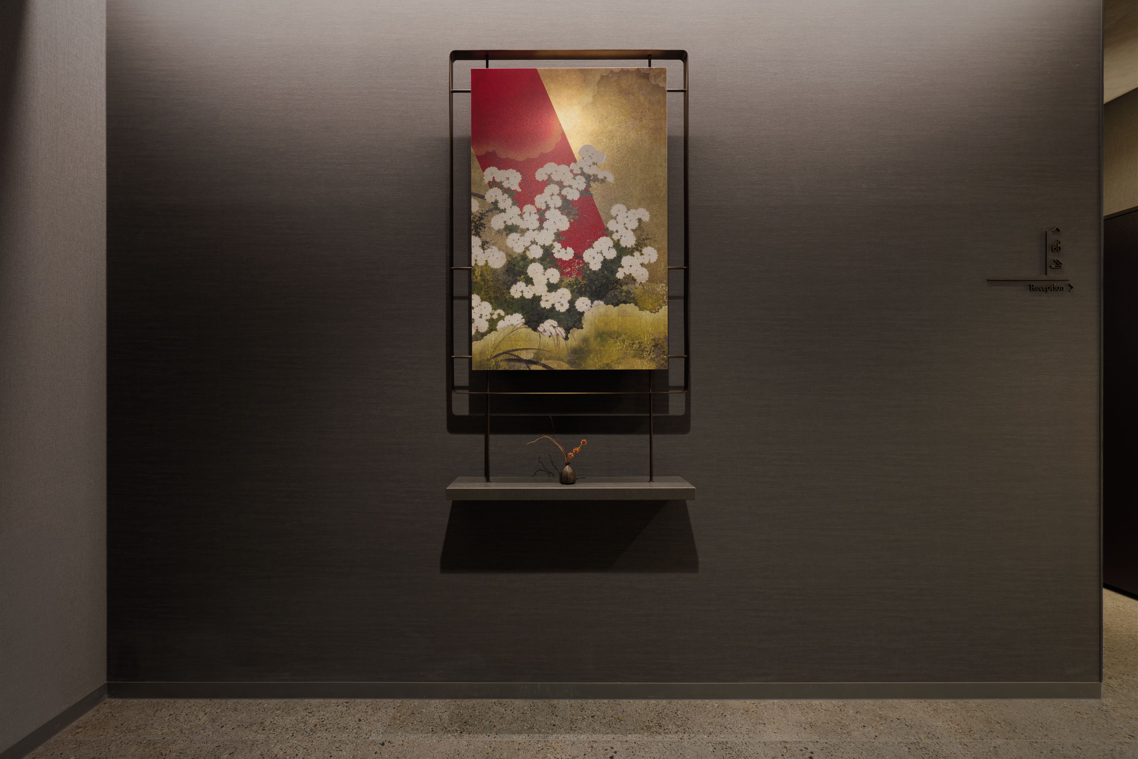 Una obra d'art penjada a la paret amb un disseny floral, un rètol d'informació i una nansa de porta.