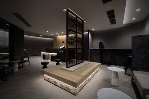 A modern reception area with a reception desk, seating, and a decorative partition. - GRAND MONday KYOTO SHIJO KAWARAMACHI (Kyoto)