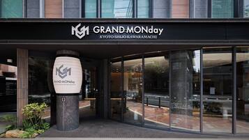 The exterior of a hotel with a modern facade, large glass windows, and a prominent logo.