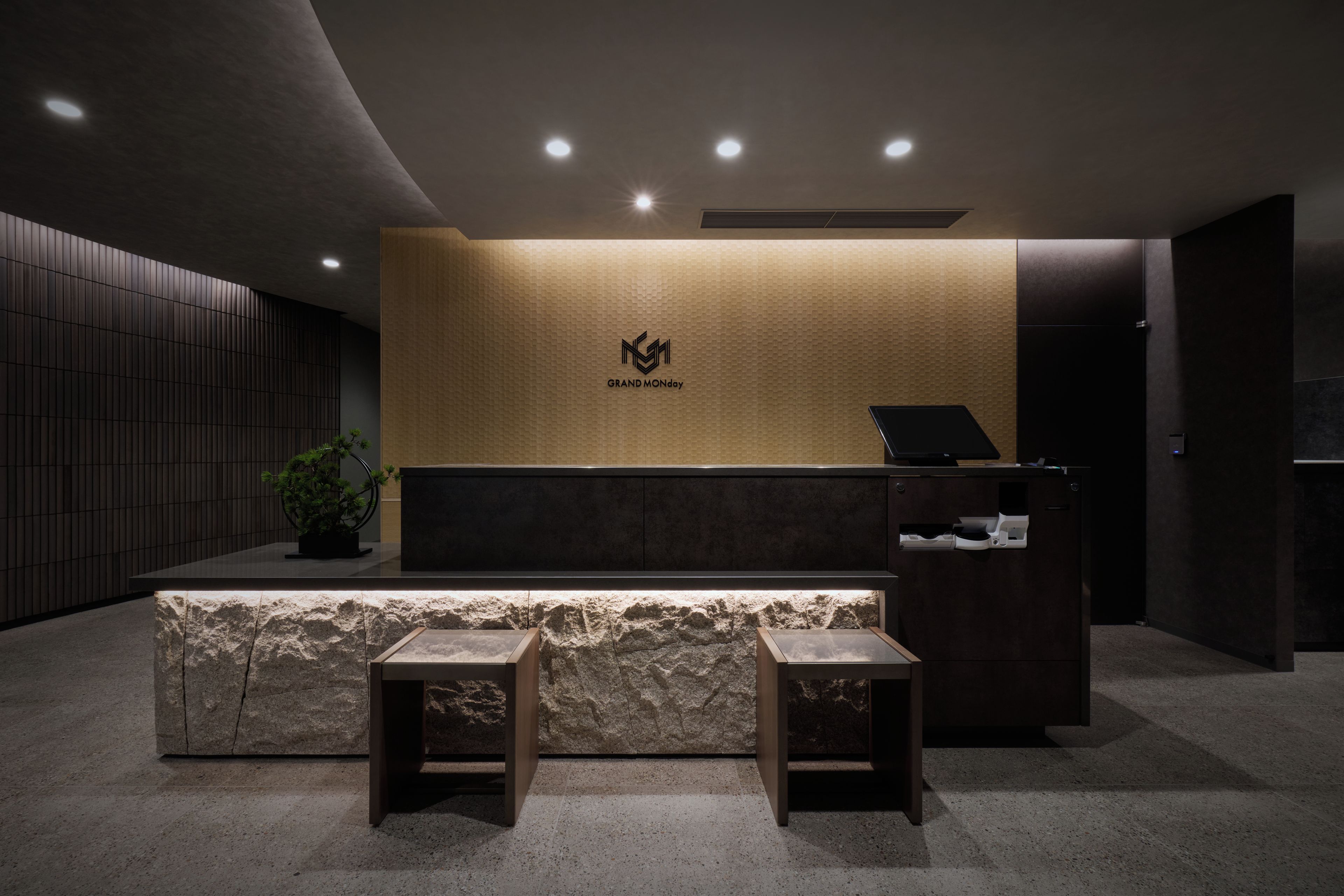 Una recepción con logotipo, una planta y un área de asientos.