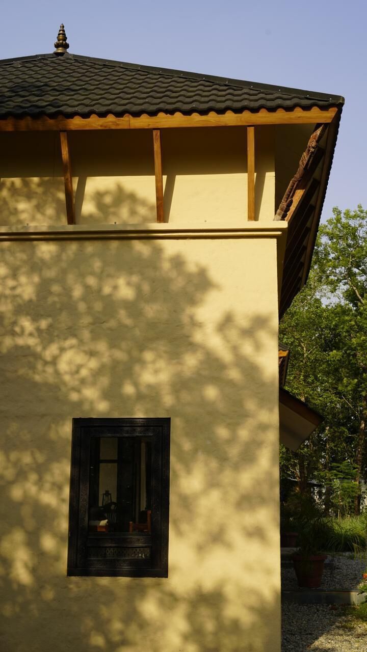 Un edificio con techo de tejas, una ventana y una estructura de madera encima.