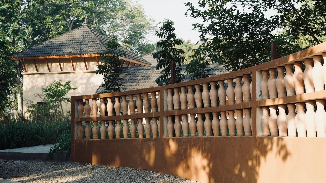 A wooden fence with a series of vases.