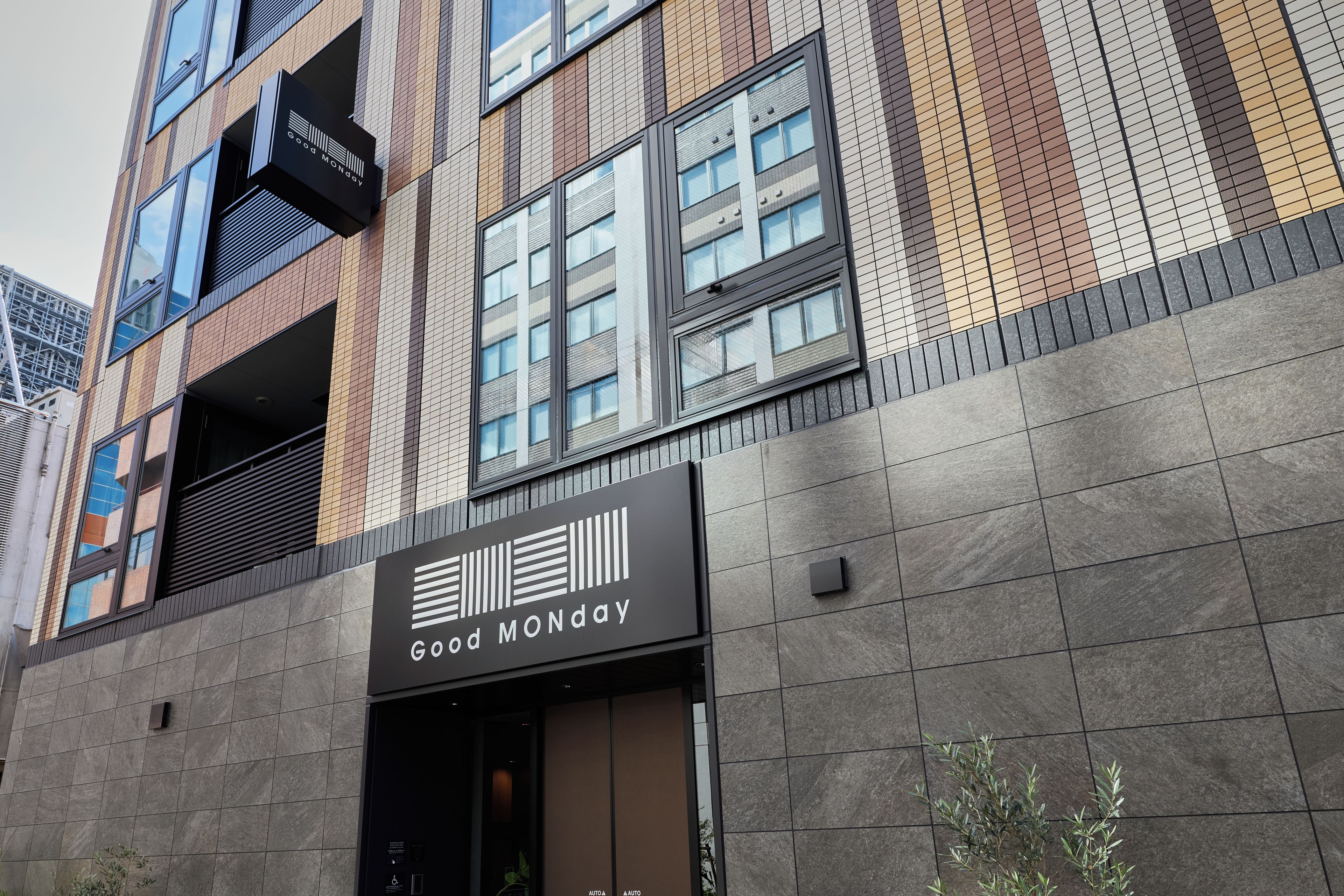 A building facade with a 'Good Monday' sign, large windows, and a modern architectural design.