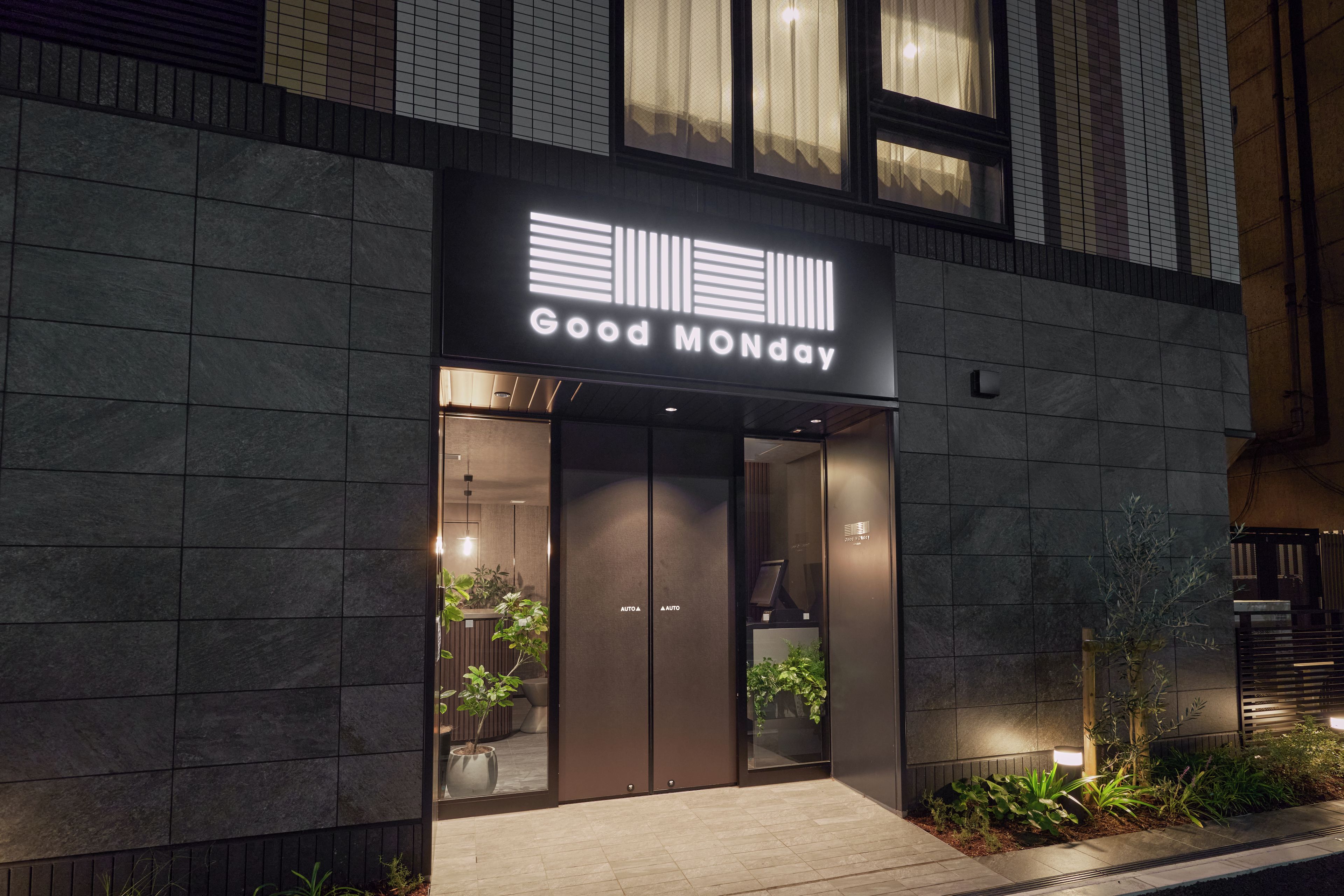 A building with a sign reading 'Good Monday' and a modern entrance with glass doors.