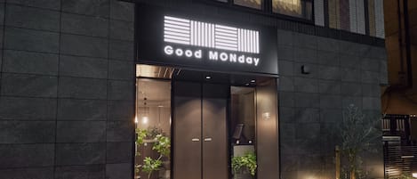A building with a sign reading 'Good Monday' and a modern entrance with glass doors.