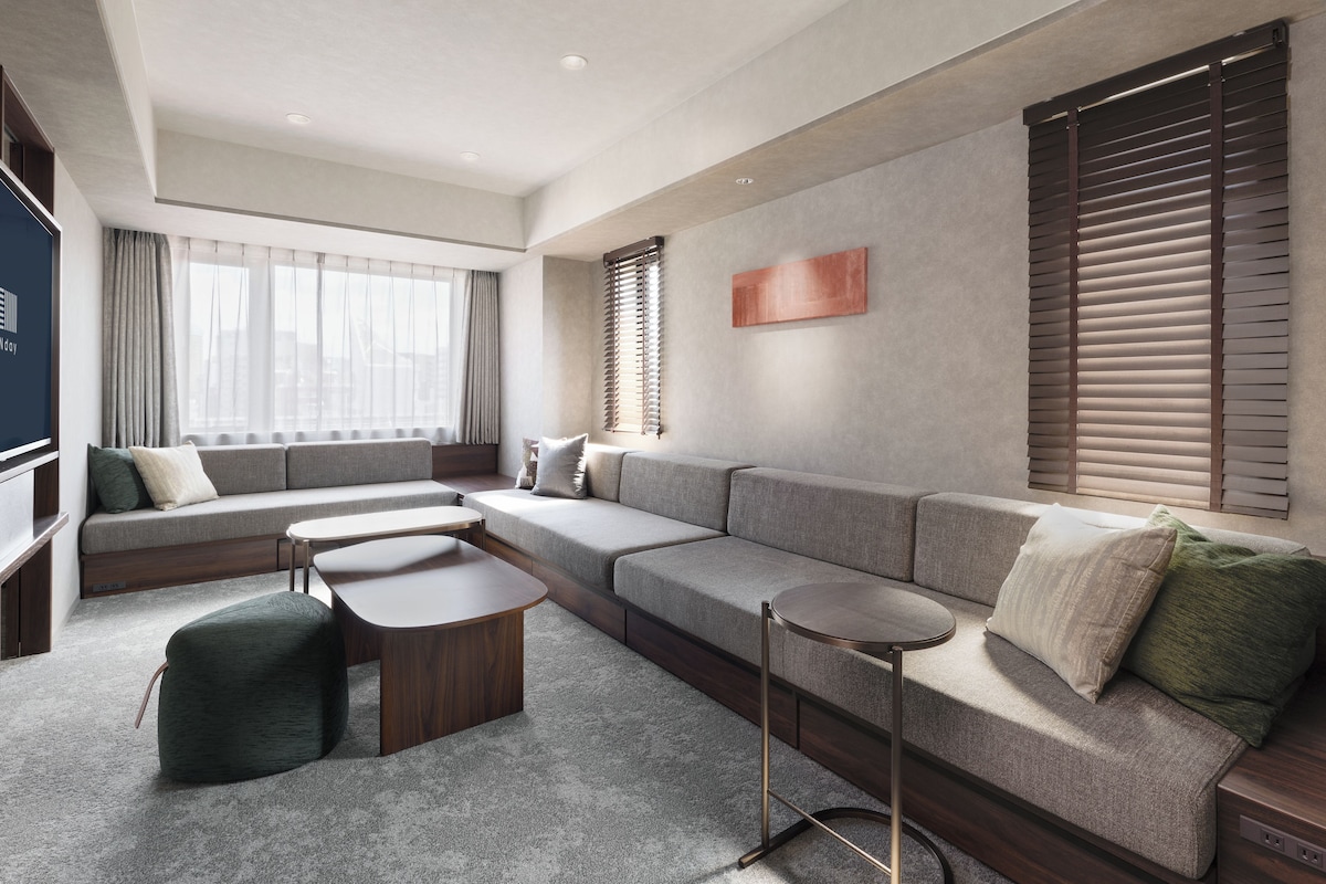 A modern living room with a sectional sofa, a coffee table, and a TV.