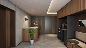 A modern reception area with a reception desk, seating, and a potted plant.