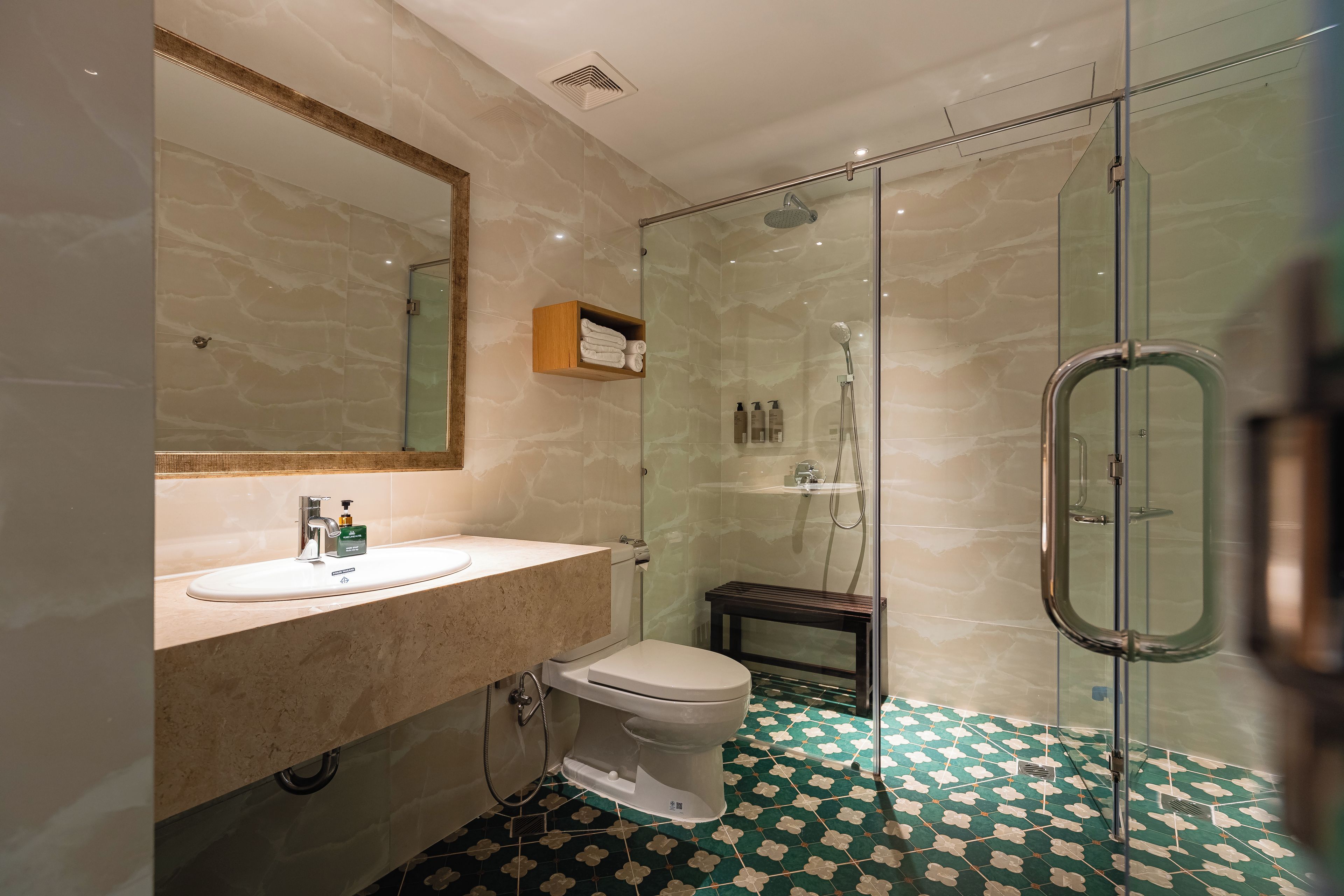 Une salle de bain moderne avec une douche à parois de verre, un lavabo en marbre et des toilettes.