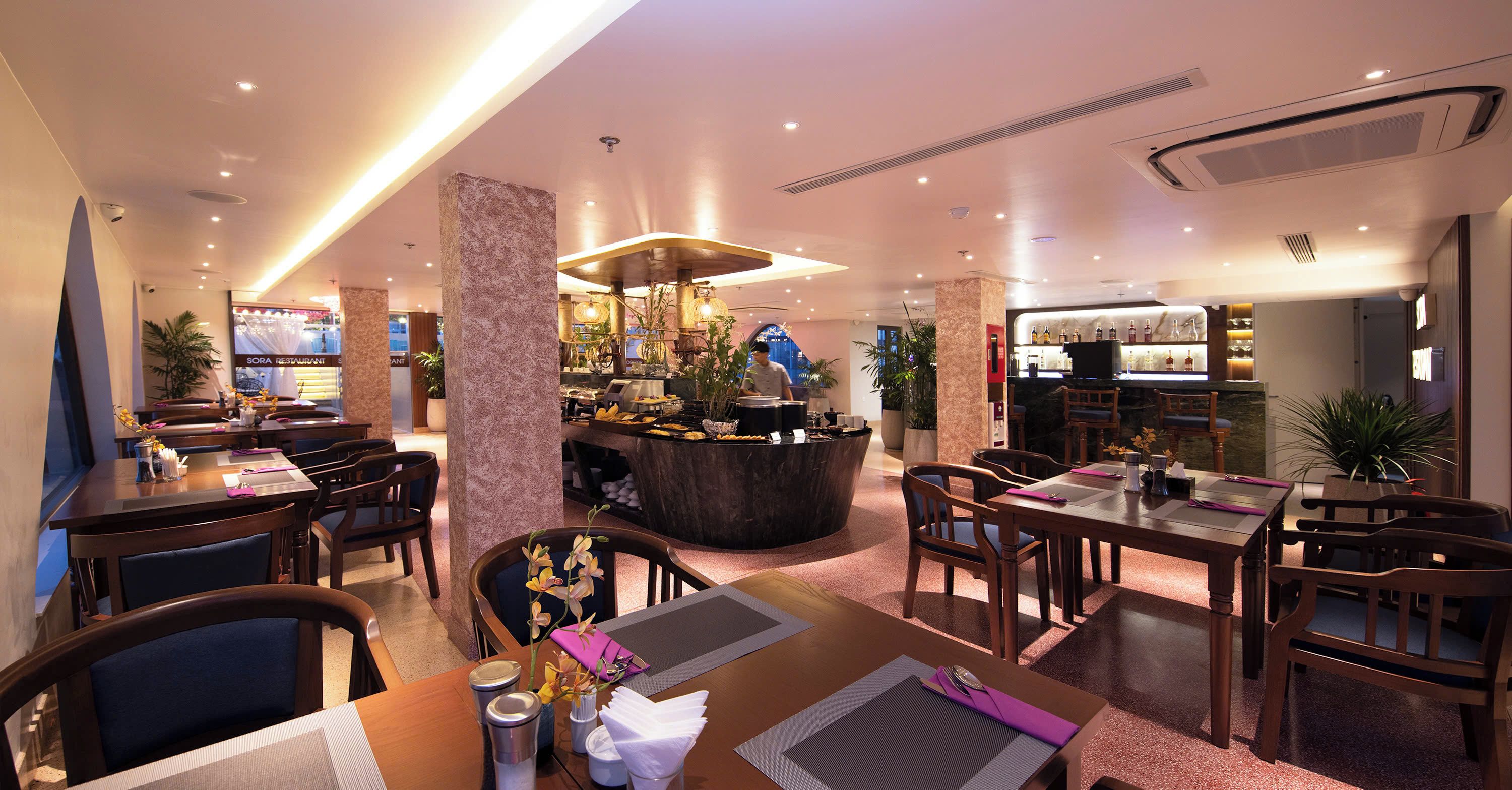 Un restaurant doté d’un bar, de plusieurs tables et de chaises.