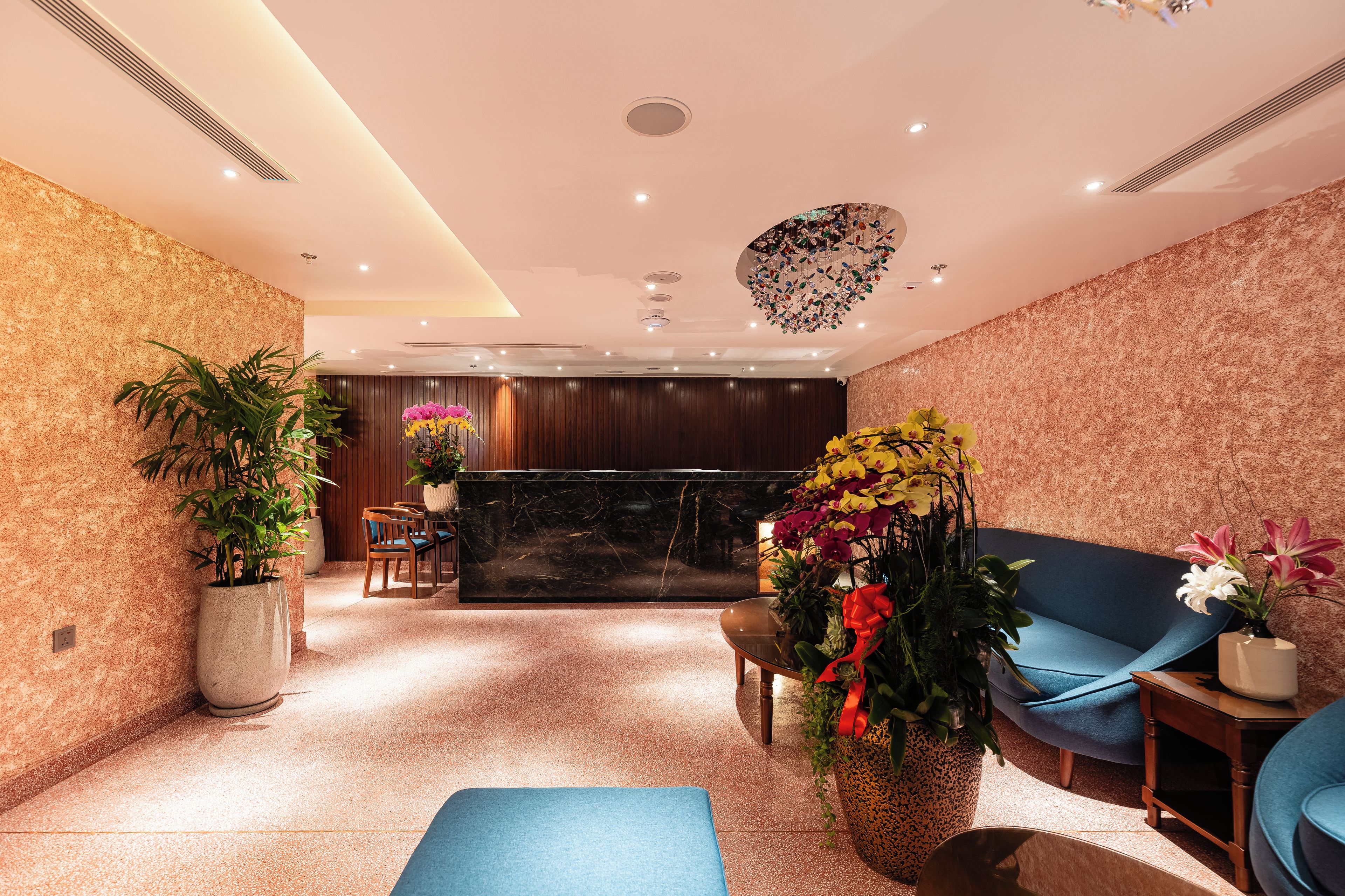 Eine moderne Lobby mit einer Rezeption, einer Sitzecke und dekorativen Pflanzen.
