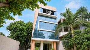 Un moderno edificio de hotel con un letrero que dice 'HOTEL' y 'OVO-Serviced', indicando servicio de habitaciones.