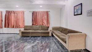 Una habitación con dos sofás, un ventilador de techo y un cuadro en la pared.