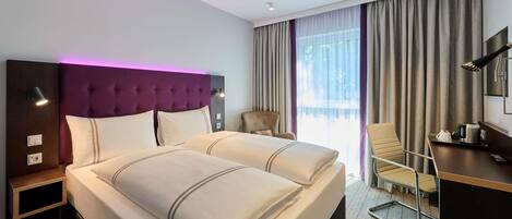A hotel room with a large bed, a desk, a chair, and a view of the outdoors.