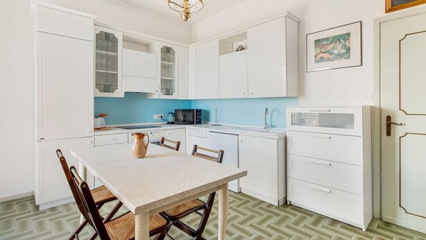 A kitchen with white cabinets, a dining table, and chairs. - [Casa Azzurra] Terrace/Seaview (Lerici)