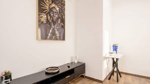 A modern interior with a dark console table, a white side table with a vase, and a framed artwork on the wall. - ALL Covi del Viaggiatore – Elegant 2-Bedroom Stay in Bari (Bari)