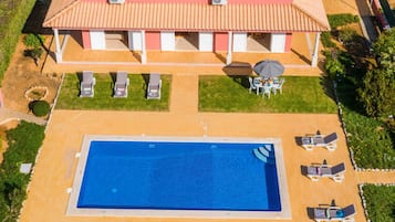 A large house with a swimming pool and outdoor seating.