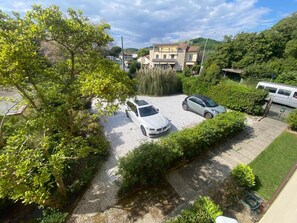 Una zona residencial con dos coches aparcados, un edificio con un cartel y un área con césped.