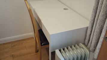 A small, white, rectangular room with a wooden chair and a radiator.