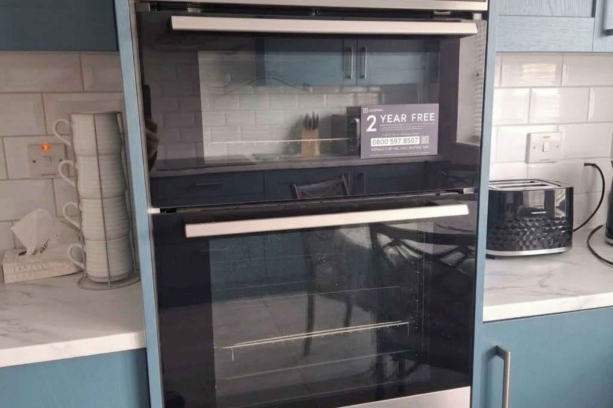 A kitchen with a built-in oven and a 2-year free offer sign.