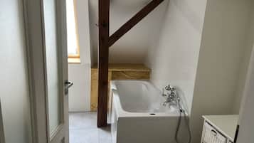 A bathroom with a bathtub, a shower, and a wooden beam structure.